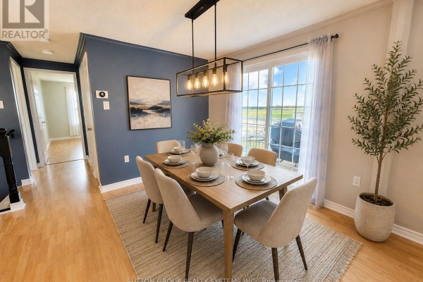 Open concept living and dining room with hardwood floors, a sectional sofa, and a wooden dining table. - Main Floor - 62 Laidlaw Drive, Barrie