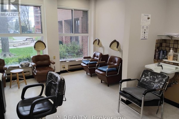 Three hair washing stations with chairs and sinks against a tiled wall. - Main Floor - 7900 Mclaughlin Road, Brampton