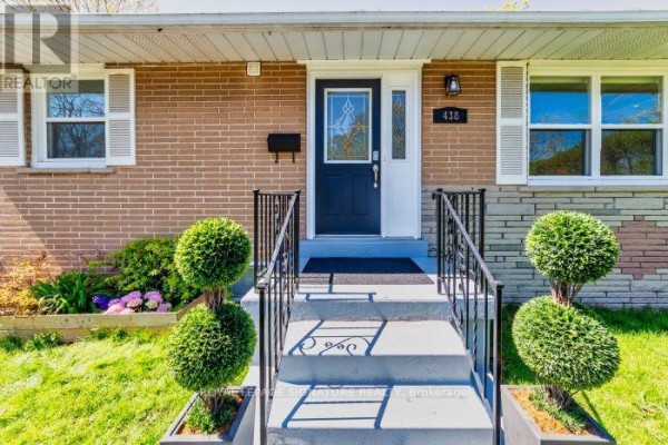 Close-up of the front entrance with a dark blue door, glass sidelight, and brick facade. - Main Floor Apartment - 438 Third Line, Oakville