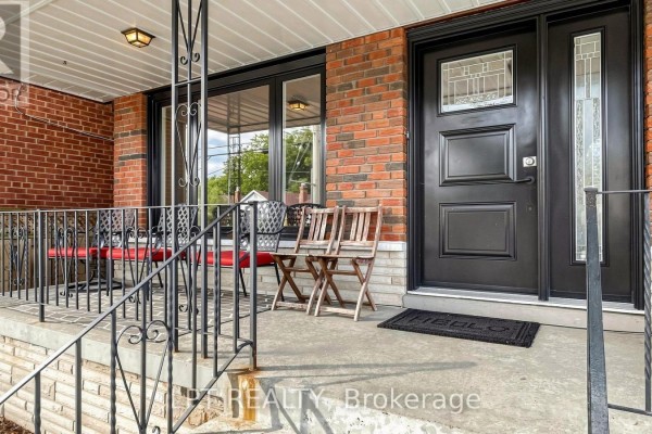 Detail view of the front door and porch of a brick house with black accents. - Main Floor Apt. - 477 Cosburn Avenue, Toronto