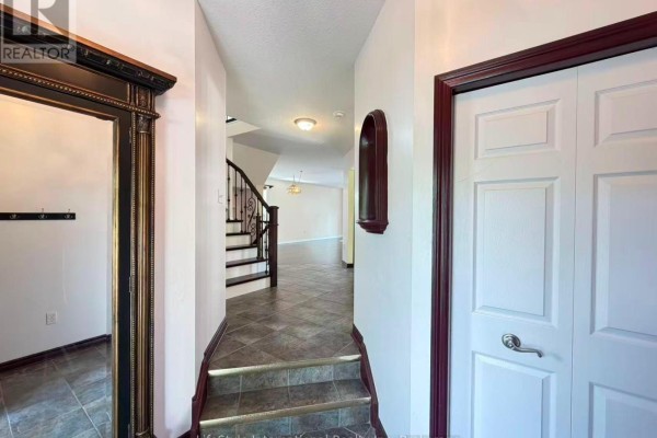 View of the foyer staircase with dark wood treads and white risers, leading to the upper floor. - Main Unit - 16 Lynch Circle, Guelph