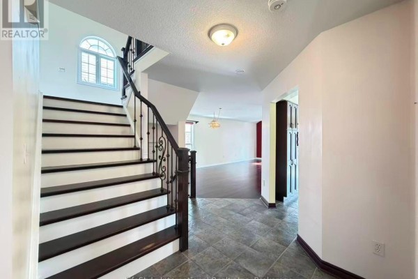 View into a powder room with a vanity, toilet, and tiled floor, adjacent to a hallway. - Main Unit - 16 Lynch Circle, Guelph