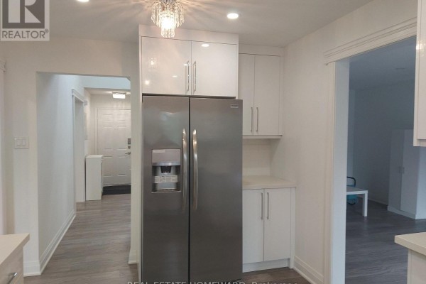 Modern kitchen featuring stainless steel refrigerator, white cabinetry, and tile backsplash. View of the foyer and hallway. - Main2nd - 413 Carrville Road, Richmond Hill