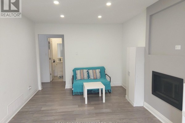 Living room with grey walls, a turquoise futon, white coffee table, and a modern fireplace. View of the hallway. - Main2nd - 413 Carrville Road, Richmond Hill