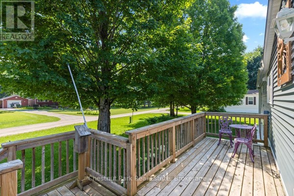 Living area with rocking chair, patterned curtains, windows, and a sofa with a blue throw. - Mh15 - 684138 Sideroad 30, Chatsworth