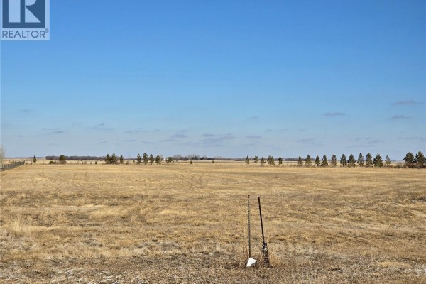 Open, dry field with tall grass, a fence line, and two upright posts in the foreground. - Minard South Lot 2, Weyburn Rm No  67