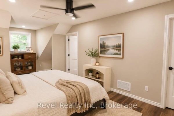 Neutral-toned bedroom with bed, ceiling fan, dresser, artwork - N/a - 157 Desroches Trail Tiny