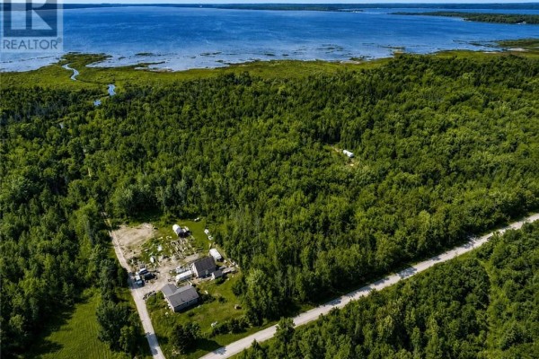 Aerial view of wooded property with buildings and a lake in the distance. - N/a 4th Line, Gore Bay