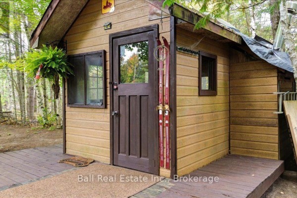 Small wooden cabin with a brown door, window, and a deck, set among trees. - N/a Coon Lake Road, North Kawartha