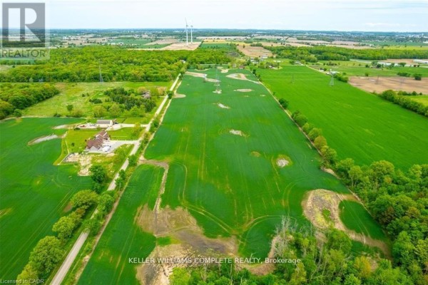 Aerial view of open farmland with rows of crops and distant wind turbines. - N/a Joslin Road, West Lincoln