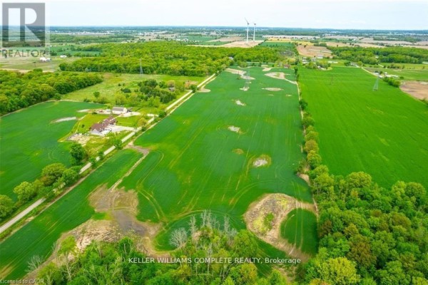 Aerial view of expansive farmland featuring green fields, trees, and a rural road. - N/a Joslin Road, West Lincoln