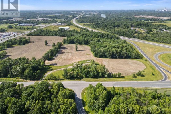 Aerial view of rural land with fields, trees, and highway infrastructure in the distance. - N/a Lyons Creek Road, Niagara Falls