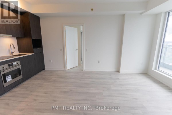 View of the modern kitchen and living space from another angle, showing an open doorway. - N2610 - 7 Golden Lion Heights, Toronto