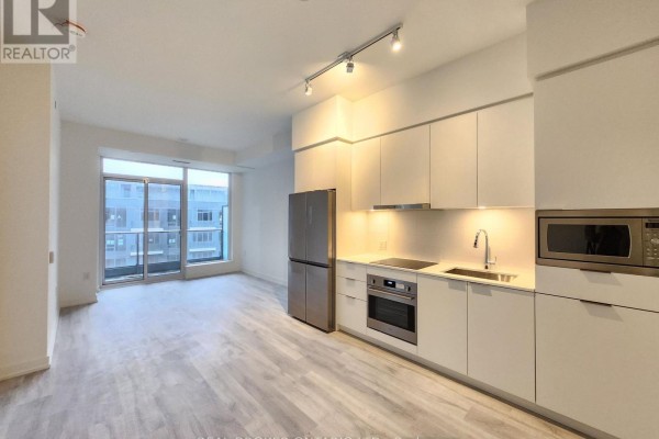 Open concept living area with a modern kitchen featuring white cabinets and stainless steel appliances. - N625 - 7 Golden Lion Heights, Toronto