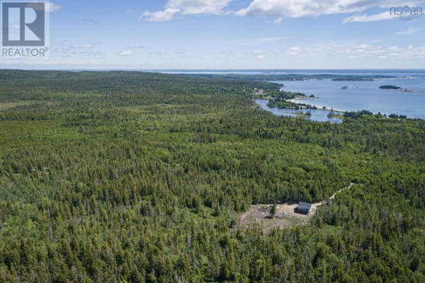 Expansive aerial view of forested land leading to a distant coastal village and ocean. - Northern Hill Road, Bayswater