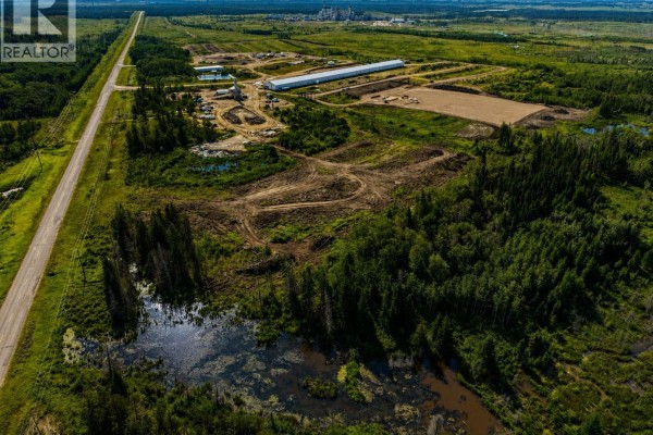 Aerial view of Northgate Industrial Lot 2, showing cleared land, trees, a road, and distant industrial buildings. - Northgate Industrial Lot 2, Buckland Rm No  491