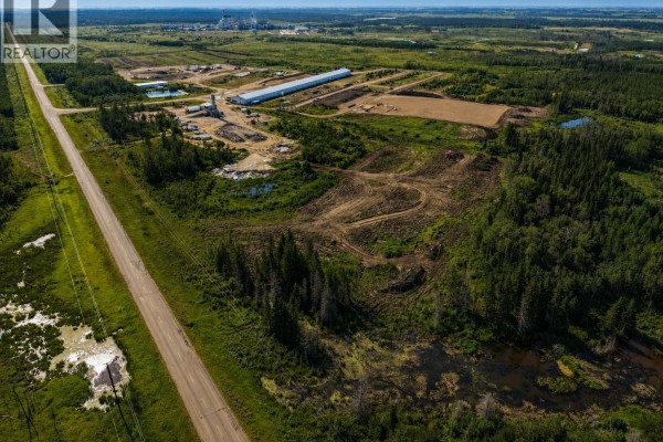 Wide aerial view of Northgate Industrial Lot 2, showing cleared land, trees, a road, and distant industrial structures. - Northgate Industrial Lot 2, Buckland Rm No  491