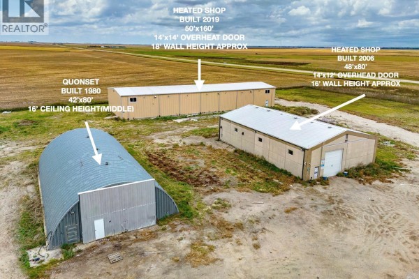 Exterior view of a quonset hut and two tan heated shops of varying sizes. - Nw 17-14-15 W2m, Francis Rm No  127