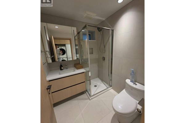 Bathroom with a vanity, sink, glass-enclosed shower, and white toilet. - One Bedroom Basement-xx W 63 Avenue, Vancouver