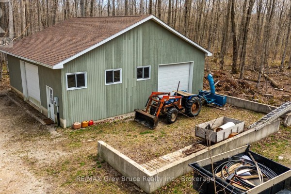 Side view of the detached garage with a tractor and snowblower. - Part 10 Tammy's Cove Road, Northern Bruce Peninsula