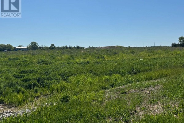 Wide, green grassy field with dirt path on the right under a clear blue sky. - Part 7 Fullerview Drive, Central Huron