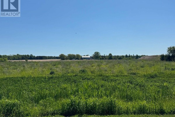 Open green field with distant buildings and trees under a clear blue sky. - Part 7 Fullerview Drive, Central Huron