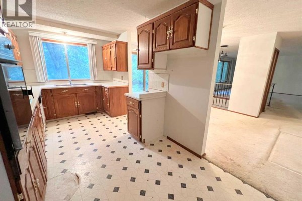 U-shaped kitchen with wood cabinets, laminate counters, and checkered floor. - Part Of Ne-8-66-22-w4, Athabasca