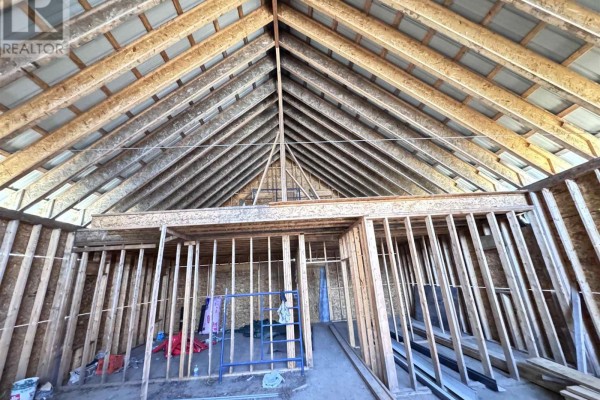 Interior view of unfinished construction with exposed wooden beams, studs, and insulation. - Pcl 50 Dog Lake, Missanabie
