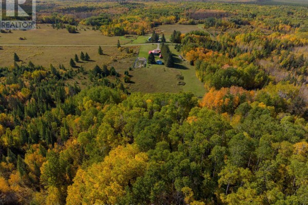 View of a log cabin with a red roof and a small white building, with lush green lawns and trees. - Pcl23545 Sec 16 Lauzon Road, Rainy River Remote Area