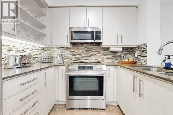 Detailed view of a U-shaped kitchen with stainless steel appliances and tiled backsplash. - Ph 10 - 55 Oneida Crescent, Richmond Hill