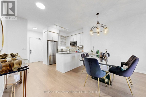 Combined living, dining, and kitchen area with light wood floors and large windows. - Ph 10 - 55 Oneida Crescent, Richmond Hill