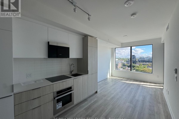 Open concept living area with a modern kitchen, light wood cabinets, and large window. - Ph04 - 28 Eastern Avenue, Toronto