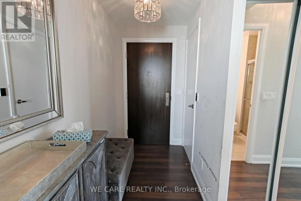 Entryway with a dark wood door, a bench, a mirror, and a tissue box. - Ph05 - 68 Canterbury Place, Toronto