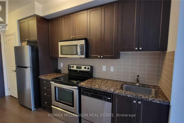 View of the kitchen featuring dark wood cabinetry, granite countertops, stainless steel appliances and a tiled backsplash. - Ph08 - 1060 Sheppard Avenue, Toronto
