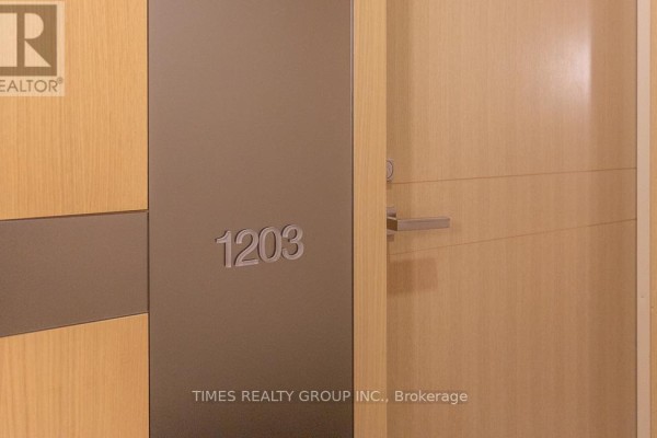 Close-up of apartment door with brushed metal accent and the number 1203. - Ph1203 - 39 Queens Quay E. Street E, Toronto