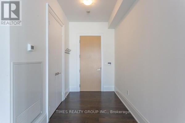 Apartment entryway with dark wood floors, white walls, and closet doors. - Ph1203 - 39 Queens Quay E. Street E, Toronto