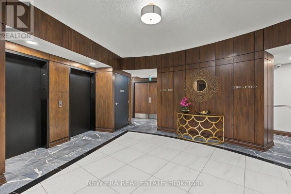 Apartment building hallway with dark wood paneling, black elevators, and marble flooring. - Ph20 - 8201 Islington Avenue, Vaughan