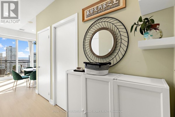 Hallway view towards balcony with city view and table with chairs. - Ph2612 - 225 Sackville Street, Toronto
