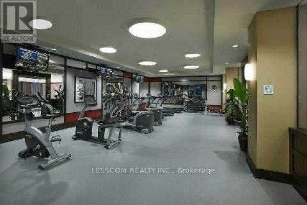 Well-equipped fitness center with treadmills, ellipticals, weight machines, and television screens. - Ph28 - 2 Eva Road, Toronto