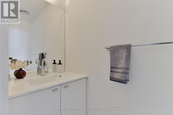 White vanity with a sink, chrome faucet, and mirrored wall. - Ph3505 - 105 The Queensway Avenue, Toronto