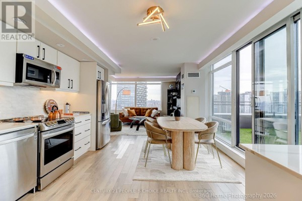 Close-up of kitchen featuring white cabinetry, quartz countertops, and stainless steel stove. - Ph5201 - 25 Telegram Mews, Toronto