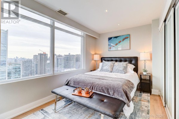 Cozy living area with circular rug, accent chairs, and decorative lighting. - Ph5201 - 25 Telegram Mews, Toronto