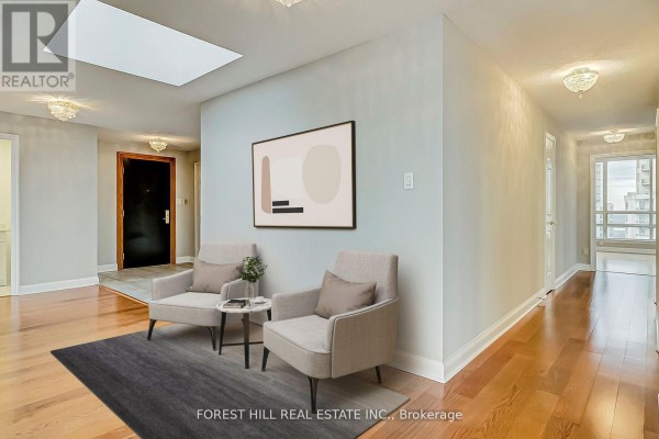 Bright hallway with two armchairs, a skylight, and modern artwork - Ph7 - 55 Kingsbridge Garden Circle, Mississauga