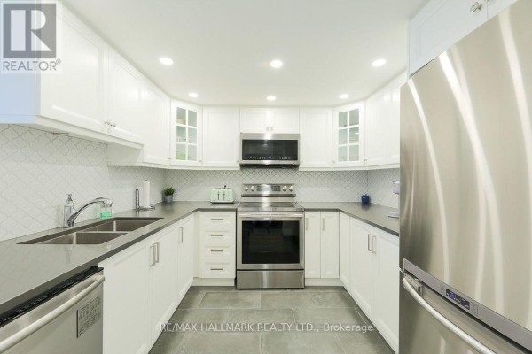 U-shaped kitchen with white cabinets, stainless steel appliances, and grey countertops. - Ph83 - 1 Greystone Walk Drive, Toronto