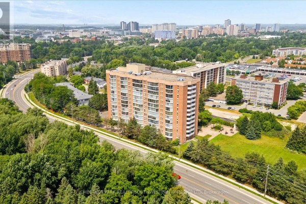 Aerial perspective of the apartment building and surrounding urban environment with a road and parking lot. - Ph9 - 265 Westcourt Place, Waterloo