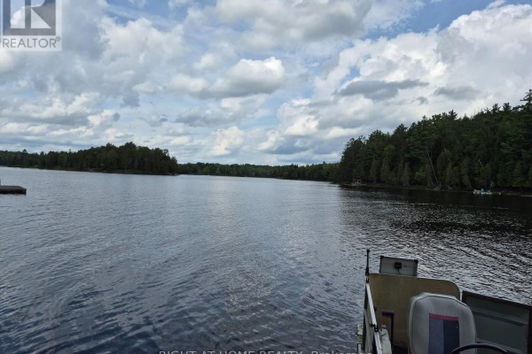 Wide view of a lake from a boat with tree-lined shores under a partly cloudy sky. - Pt 3 Shadows End Lane, Magnetawan