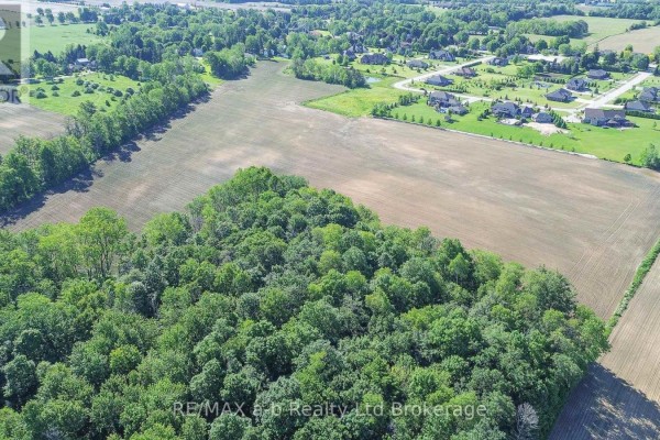 Aerial view showcasing a dense treed area bordering cultivated fields and suburban homes. - Pt Lt 15, Con 1 Pt 1 & 2 Deer Crescent, Norwich