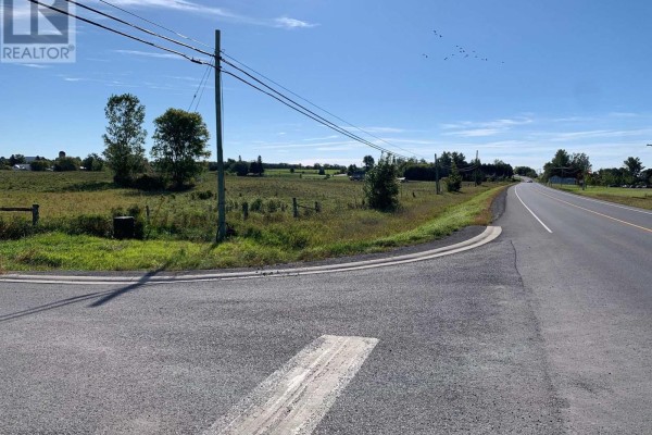 Wide aerial view of the land parcel and surrounding agricultural fields, roads, and a small creek. - Pt Lt 19 Con 4 County Rd 8, Greater Napanee