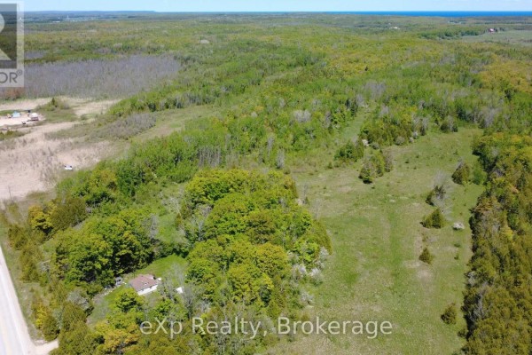 Expansive aerial view of undeveloped land featuring mixed forests, fields, and a straight highway. - Pt Lt 36-37 Con 3 Highway 6 Road, Northern Bruce Peninsula