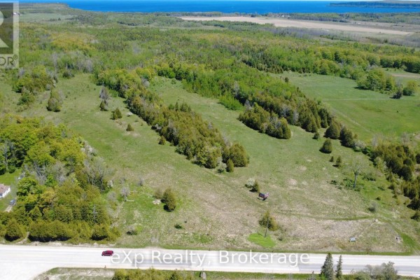 Panoramic aerial perspective of forested land meeting a distant blue ocean under a clear sky. - Pt Lt 36-37 Con 3 Highway 6 Road, Northern Bruce Peninsula